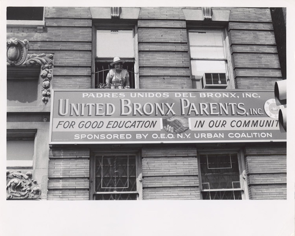 Director Evelina Antonetty of Bronx United Parents, Inc. in window of organization offices, Bronx, NY